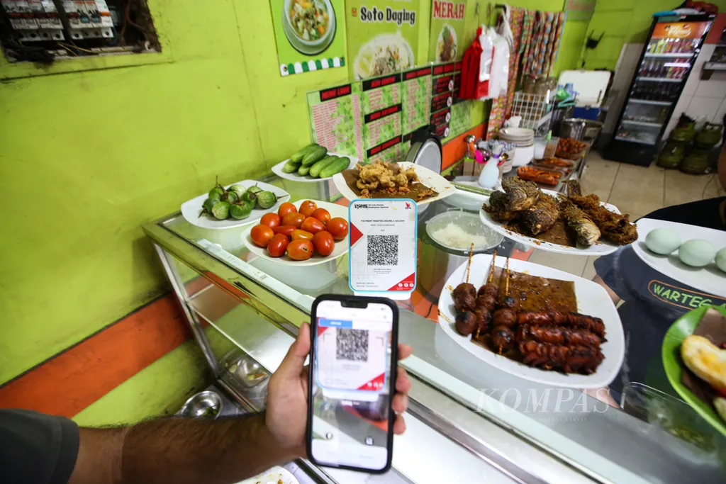 Pelanggan melakukan pembayaran dengan menggunakan qris di warung tegal atau warteg Agung 2 di kawasan Kebayoran Baru, Jakarta Selatan, Senin (11/11/2024). Pelaku usaha kecil menyambut baik kebijakan penghapusan piutang UMKM oleh Presiden Prabowo Subianto.