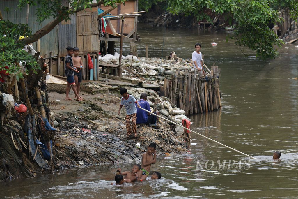 Sejumlah anak berenang di Kali Ciliwung, Kecamatan Jatinegara, Jakarta Timur, Kamis (2/1/2023).