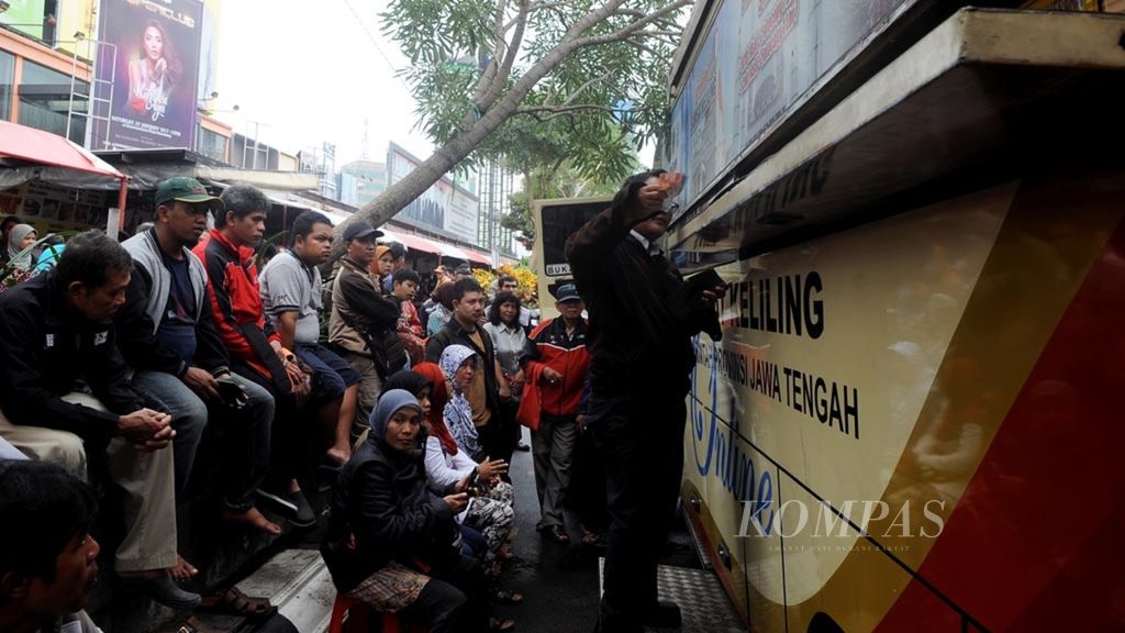 Pajak Kendaraan Bermotor - Warga mengantre untuk membayar pajak kenadaraan bermotor melalui mobil Samsat Keliling di kawasan Simpang Lima, Kota Semarang, Jawa Tengah, Kamis (5/1). Pemerintah mulai memberlakukan tarif baru biaya pengurusan surat-surat kendaraan dengan kenaikan dua hingga tiga kali lipat dari sebelumnya.