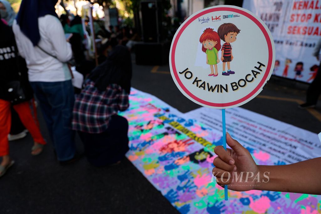 Salah satu aktivis membawa pesan kampanye tentang isu pernikahan dini di Jalan Slamet Riyadi, Kota Surakarta, Jawa Tengah, Minggu, 24 Juli 2022. 