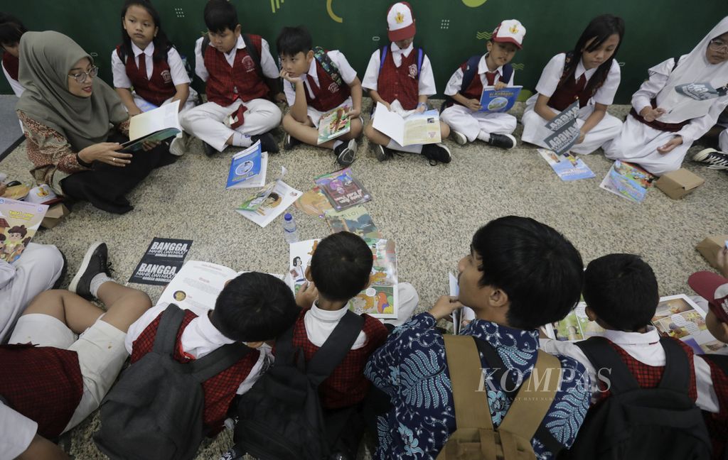 Guru mendongengkan dari buku cerita kepada murid-muridnya dalam pameran Bulan Bahasa dan Sastra 2024 di Kantor Kementerian Pendidikan Dasar dan Menengah (Kemendikdasmen), Jakarta, Senin (28/10/2024).