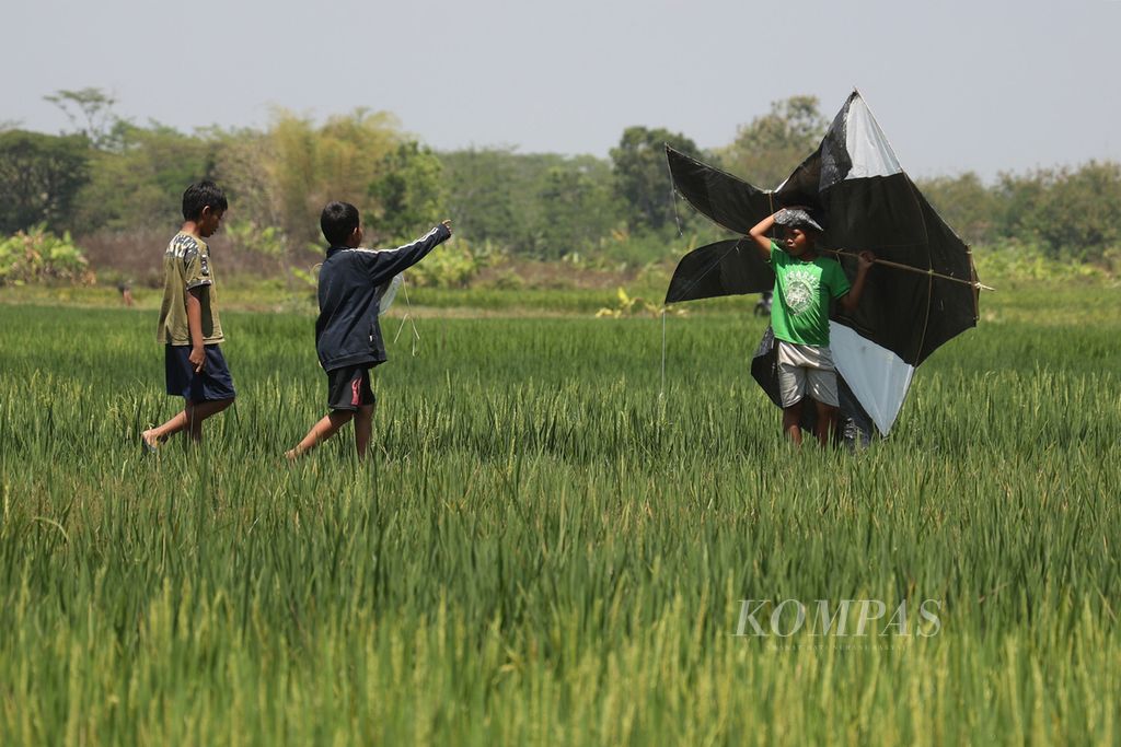 Anak-anak bermain layang-layang saat acara Ngaran Kite Festival di Dusun Ngaran, Desa Margokaton, Seyegan, Sleman, DI Yogyakarta, Sabtu (9/9/2023).  Selama kegiatan ini berlangsung, seluruh pengunjung dilarang menggunakan kemasan plastik sekali pakai sebagai upaya edukasi tentang kelestarian lingkungan.