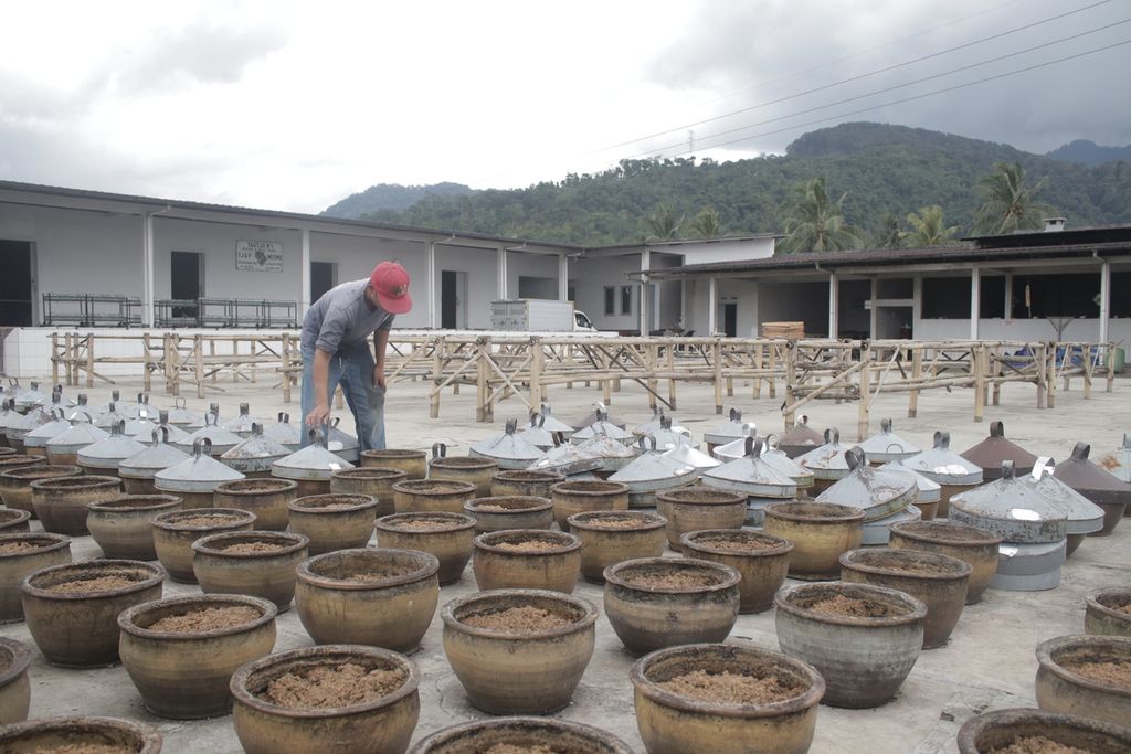 Pegawai pabrik Taoco Cap Meong, menutup guci yang berisi fermentasi kedelai di pabriknya di Jalan Raya Cipanas, Kabupaten Cianjur, Jawa Barat, Senin (28/2/2022). Fermentasi kedelai ini merupakan bahan baku taoco.
