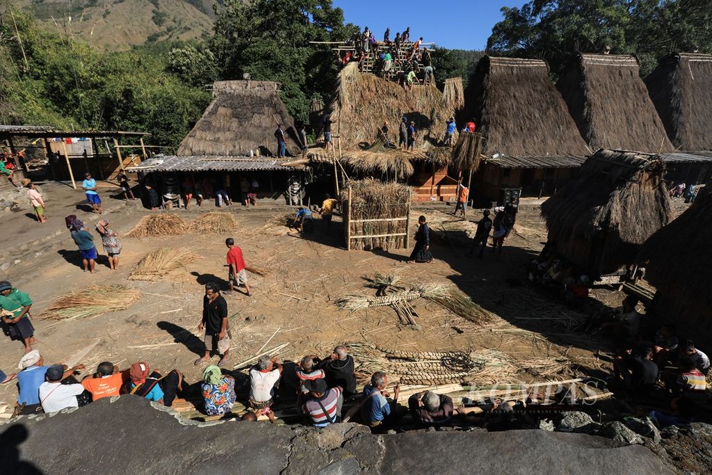 Warga kampung adat Bena bergotong royong memasang atap rumah suku Kopa di Desa Tiworiwu, Kecamatan Jerebu'u, Kabupaten Ngada, Nusa Tenggara Timur, Senin (5/8/2019). Upacara pasang atap rumah dalam bahasa setempat disebut Wae Sao. Upacara diawali dengan tarian Ja'i oleh tuan rumah dan dilanjutkan dengan pemasangan atap. Upacara tersebut diwarnai dengan makan bersama oleh seluruh warga kampung adat. 