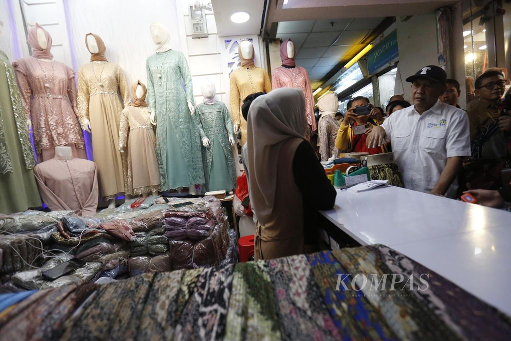 Menteri Koperasi dan UKM Teten Masduki berbincang dengan pelaku UMKM saat meninjau pusat grosir busana Tanah Abang, Jakarta, Selasa (19/9/2023). Para pedagang mengeluhkan turunnya omset karena kalah bersaing dalam harga dengan barang sejenis impor. 