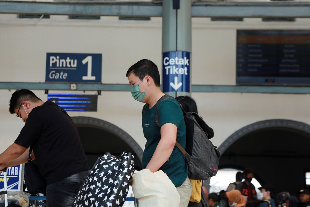 Passengers pushing suitcases to get into the train at Pasar Senen Station, Central Jakarta, Monday (19/12/2022).