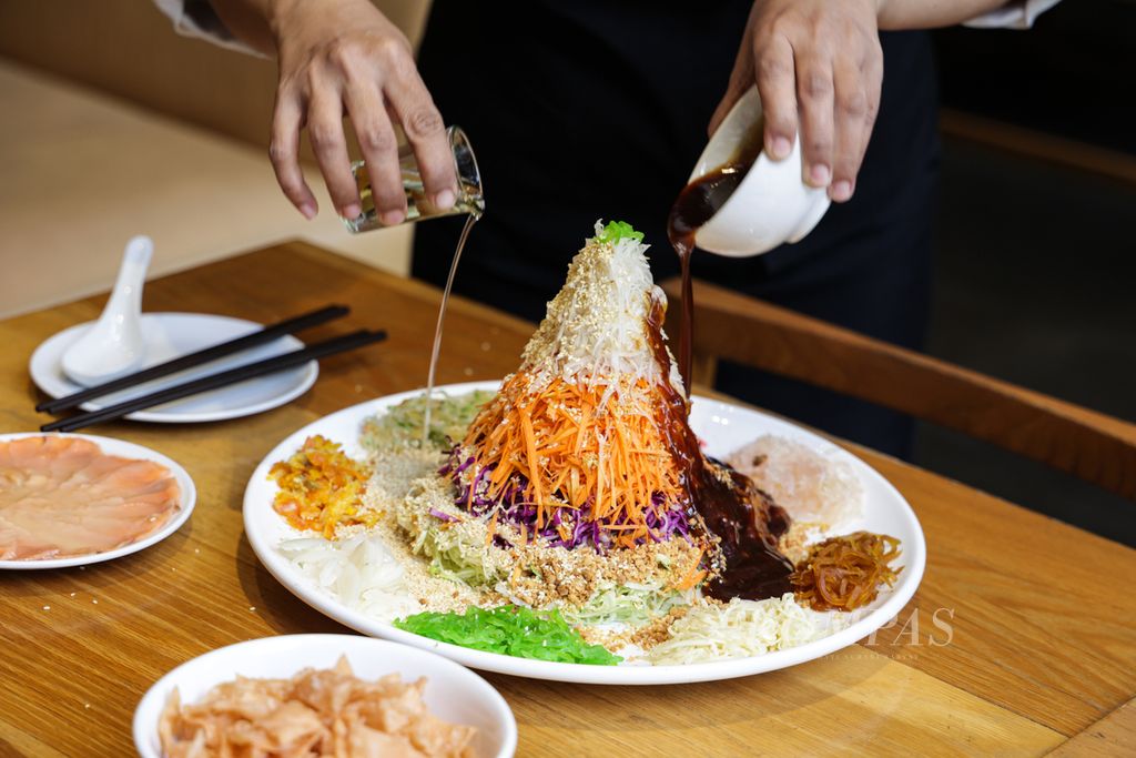 Pramusaji mencampur seluruh bahan pada menu Yu Sheng dengan disertai membaca doa dan harapan di Restoran Din Tai Fung Arcadia Senayan, Jakarta, Selasa (17/01/2023).