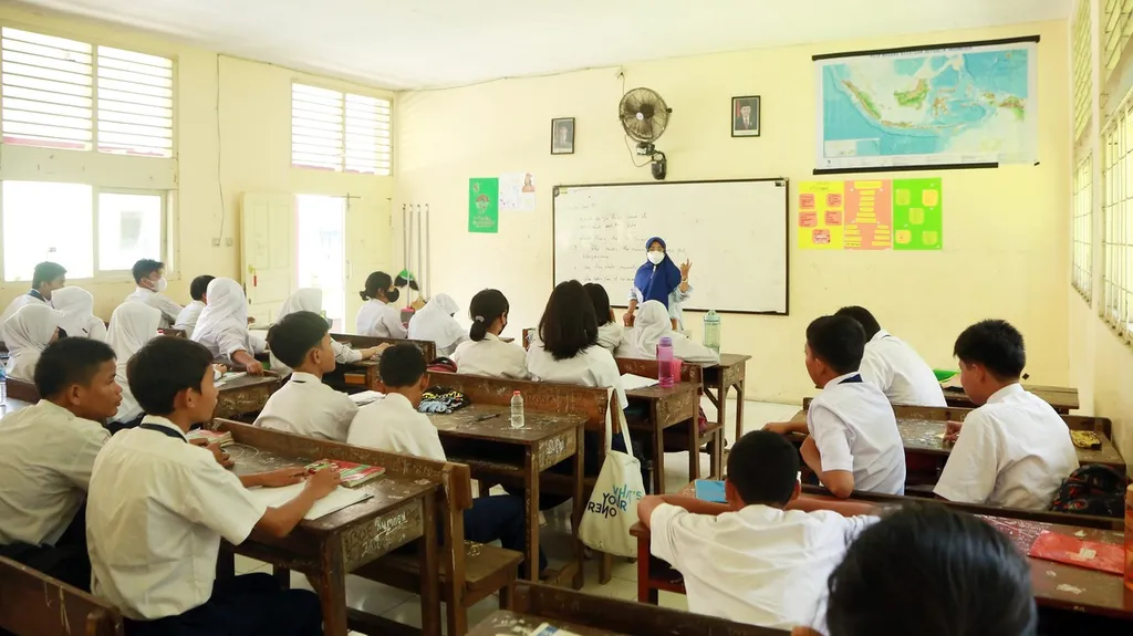 Guru Sekolah Menengah Pertama (SMP) Budaya, Dermiatin (45), memberikan penjelasan terkait mata pelajaran di SMP Budaya, Duren Sawit, Jakarta Timur, Selasa (22/11/2022). Ia telah mengajar di SMP Budaya sejak 10 tahun lalu. Ia adalah guru berstatus Prioritas 1. Sejak tahun 2021 ia telah lulus nilai minimal atau passing grade tetapi belum mendapat formasi hingga hari ini. Berdasarkan data yang disampaikan kepada Kantor Staf Presiden (KSP), dari total 193.954 guru honorer se-Indonesia yang dinyatakan lolos passing grade prioritas 1 PPPK 2021, terdapat sekitar 54.000 guru tanpa surat keputusan (SK). Ivan Dwi Kurnia Putra Selasa 22-11-2022