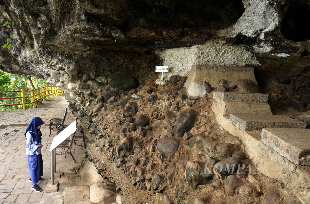 Wisatawan melihat papan informasi di depan Goa Kreo, Kecamatan Gunungpati, Kota Semarang, Jawa Tengah, Minggu (29/12/2024). Goa dengan tinggi 2,5 meter dan kedalaman 8 meter itu dipercaya merupakan salah satu tempat Sunan Kalijaga bertafakur di tengah perjalanan membawa kayu jati untuk tiang utama Masjid Agung Demak. Selama bertafakur, ada empat sosok monyet yang menghampiri dan menawarkan bantuan kepada Sunan Kalijaga. 