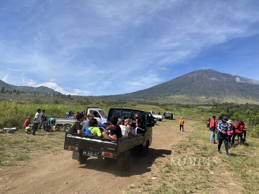Rombongan wisatawan mancanegara yang akan mendaki diangkut menggunakan kendaraan bak terbuka menuju titik awal pendakian jalur Sembalun, Lombok Timur, Nusa Tenggara Barat, Minggu (4/9/2022). .