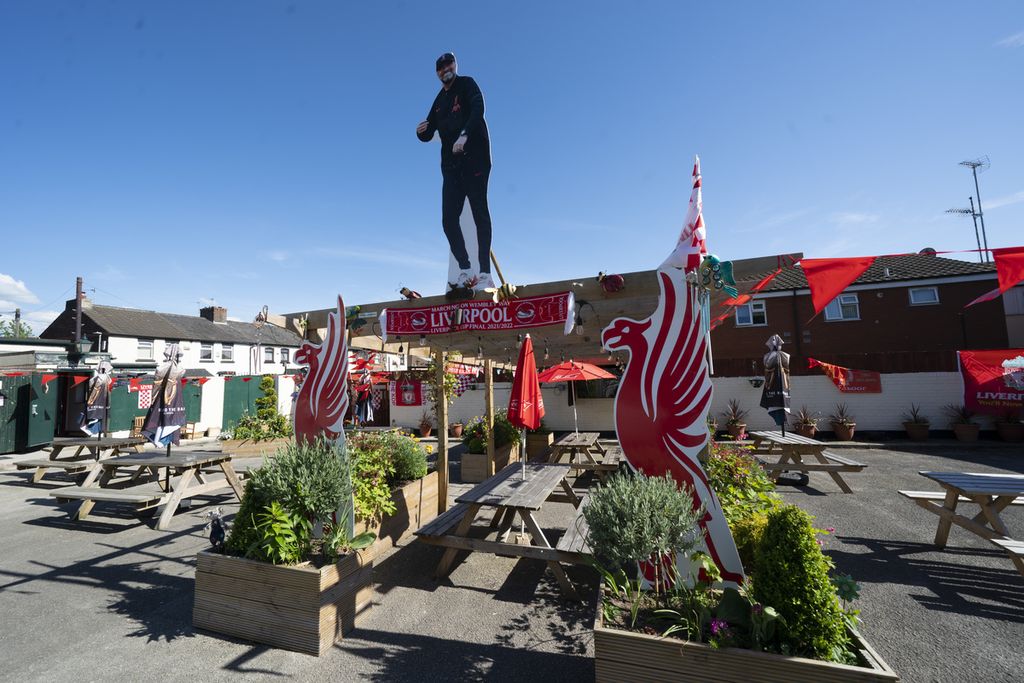 Sebuah pub di Liverpool menghias halaman dengan pernik Liverpool, termasuk foto Manajer Liverpool Juergen Klopp, Kamis (19/5/2022), menjelang laga pekan terakhir Liga Inggris, Minggu (22/5/2022). 