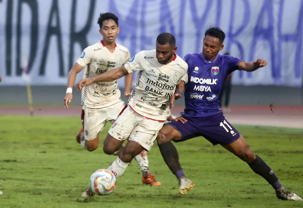 Pesepak bola Persita Tangerang Muhammad Toha (kanan) berebut bola dengan pesepak bola Bali United Jefferson Mateus (tengah) pada pertandingan BRI Liga 1 di Stadion Indomilk Arena, Kabupaten Tangerang, Banten, Selasa (30/4/2024). Persita berhasil mengalahkan tamunya dengan skor 4 - 2. ANTARA FOTO/Muhammad Iqbal/Spt.