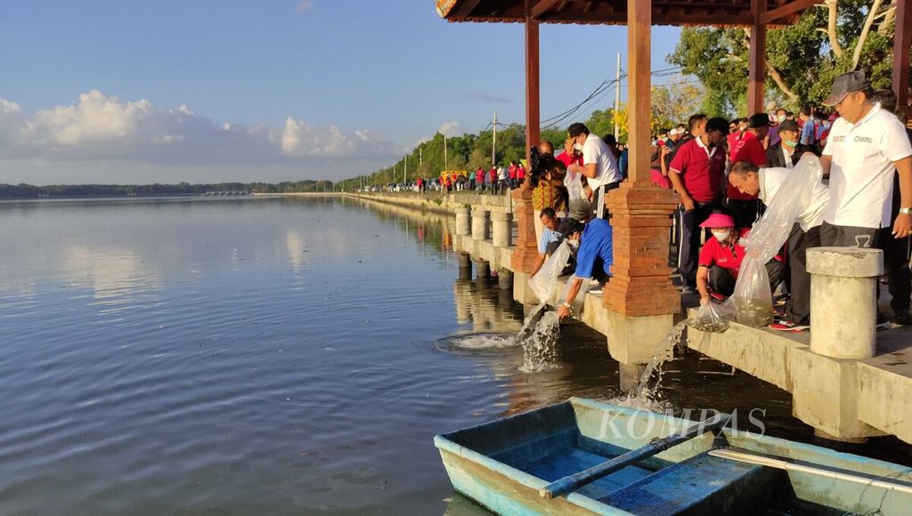 Aparatur sipil negara (ASN) di Pemprov Bali bersama masyarakat dan pelajar di Kota Denpasar mengikuti kegiatan "Resik Pesisir Pantai dan Penebaran Benih Ikan dalam Rangka Bulan Bung Karno IV" dengan menebar anak ikan dan bersih-bersih di kawasan estuari dam Suwung, Kota Denpasar, Selasa (21/6/2022).