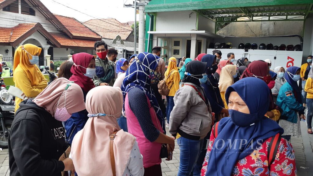Antrean meluber pencairan bantuan langsung tunai untuk korban PHK di Sidoarjo, Senin (14/12/2020). Total 5.000 karyawan yang menjadi korban PHK karena pandemi Covid-19 ini menerima bantuan Rp 600.000 per orang.