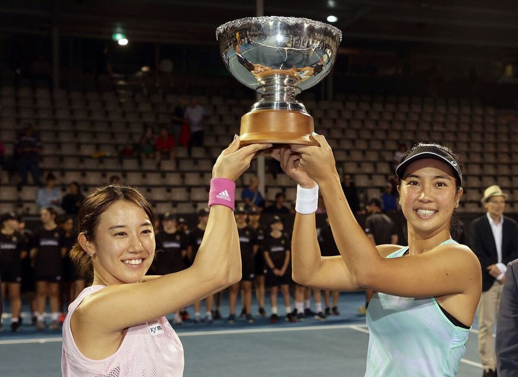 Petenis Indonesia Aldila Sutjiadi (kanan) dan petenis Jepang Miyu Kato mengangkat trofi setelah menjuarai nomor ganda putri turnamen WTA 250 Auckland di Auckland, Selandia Baru, Senin (9/1/2023). 