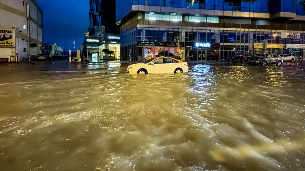 Sebuah taksi melaju menerjang banjir di tengah kota Dubai, Uni Emirat Arab, 17 April 2024. Dubai, pusat keuangan Timur Tengah, dihantam hujan badai yang memicu banjir besar.