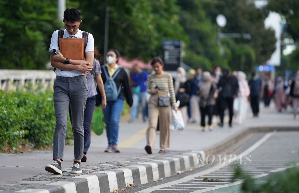 Karyawan berjalan melewati trotoar menuju Stasiun Sudirman, Menteng, Jakarta Pusat, Jumat (11/10/2024). Meski kesehatan mental pekerja berdampak besar bagi maju atau mundurnya perusahaan, banyak perusahaan di Indonesia belum memandang isu ini sebagai hal yang serius.