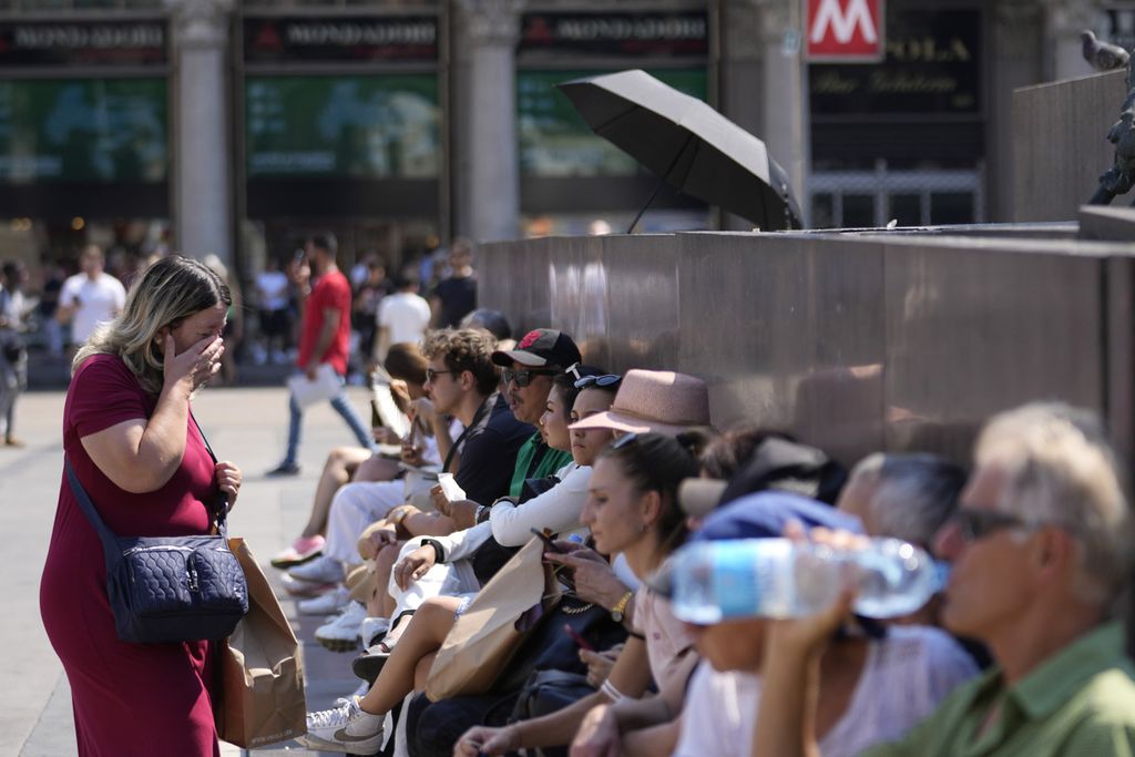 Warga beristirahat di depan katedral Duomo di Milan, Italia, 14 Juli 2022. 