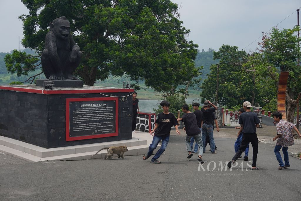 Wisatawan berlari saat didekati oleh monyet ekor panjang di Goa Kreo, Kecamatan Gunungpati, Kota Semarang, Jawa Tengah, Minggu (29/12/2024). Di tempat wisata tersebut diperkirakan ada 700 monyet jenis monyet ekor panjang (<i>Macaca fascicularis</i>) yang telah jinak dan biasa berinteraksi dengan pengunjung. Pada masa Natal dan Tahun Baru, ada 300-500 wisatawan yang berkunjung ke Goa Kreo.