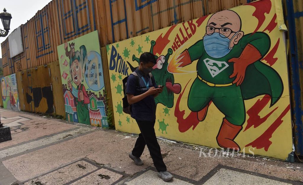 Warga melintas di depan mural bertema protokol kesehatan di Jalan Tunjungan, Kota Surabaya, Jawa Timur, Senin (21/2/2022). Mural yang sejatinya untuk mengingatkan warga agar patuh pada protokol kesehatan banyak dirusak oleh tangan yang tidak bertanggung jawab. 