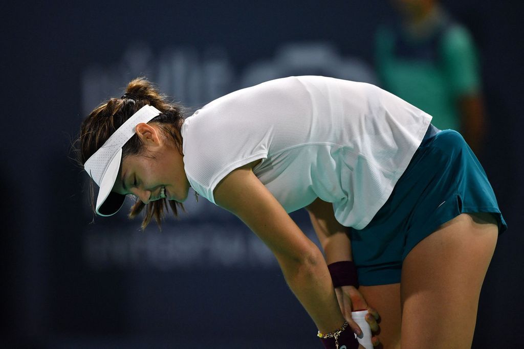 Reaksi petenis Inggris, Emma Raducanu, saat melawan petenis Tunisia, Ons Jabeur, dalam laga Kejuaraan Tenis Dunia Mubadala di Abu Dhabi International Tennis Complex, Uni Emirat Arab, Sabtu (17/12/2022) dini hari WIB. Jabeur menang dengan skor 5-7, 6-3, 10-8. 
