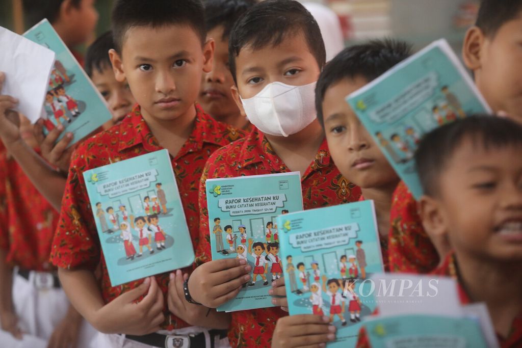 Siswa membawa buku rapor kesehatan siswa saat berlangsung pelaksanaan program imunisasi pada anak usia sekolah dasar atau BIAS (Bulan Imunisasi Anak Sekolah) di SDN 02 Pulogebang, Jakarta Timur, Kamis (10/8/2023). Sebanyak 353 siswa dari kelas 1, 2, 5 dan 6 di sekolah tersebut mendapatkan suntikan imunisasi Td, MR dan HPV. Pemerintah menetapkan bulan Agustus sebagai Bulan Imunisasi Anak Sekolah. Pada anak perempuan usia sekolah dasar kelas lima dan enam diberikan pula vaksin HPV yang berguna untuk mencegah terjadinya kanker serviks atau kanker leher rahim. 