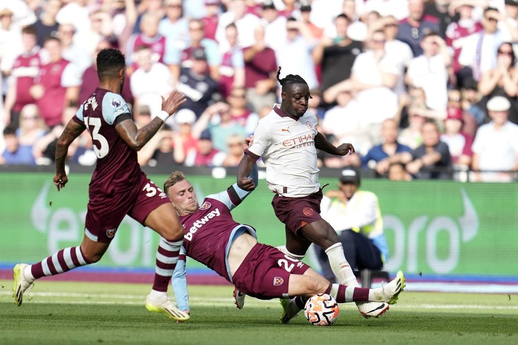Pemain West Ham Jarrod Bowen mencoba menjegal pemain Manchester City Jeremy Doku pada laga Liga Inggris di Stadion London, Sabtu (16/9/2023). City menang 3-1 pada laga itu.
