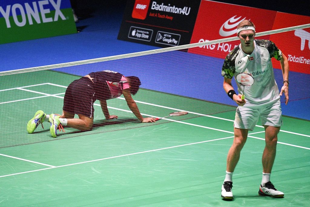 Anthony Sinisuka Ginting (kiri) berusaha bangkit setelah terjatuh saat mengejar kok melawan Viktor Axelsen (Denmark) pada laga perempat final Kejuaraan Dunia Bulu Tangkis 2022 di Tokyo, Jepang, Jumat (26/8/2022). Anthony harus mengakui keunggulan Axelsen, 10-21, 10-21.