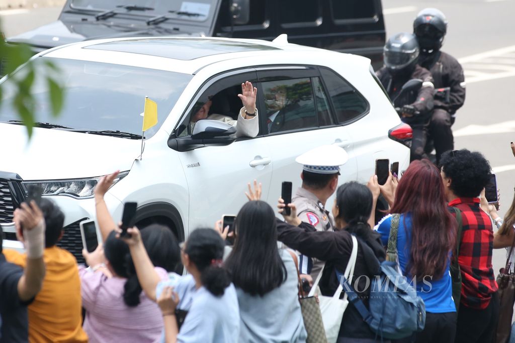 Paus Fransiskus menyapa umat saat bersama rombongan melalui Jalan Sudirman menuju Kedutaan Besar Takhta Suci Vatikan di kawasan Gambir, Jakarta, Selasa (3/9/2024). 