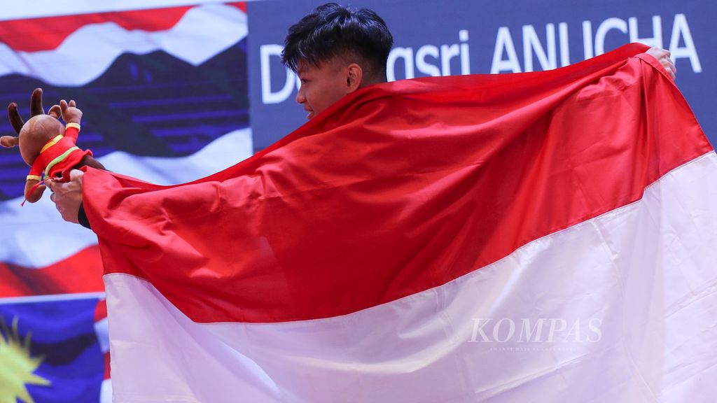 Selebrasi lifter Indonesia, Rahmat Erwin Abdullah, setelah penganugerahan medali yang diperolehnya dalam nomor 73 kilogram putra cabang angkat besi pada SEA Games Vietnam 2021 di Hanoi Training Center, Hanoi, Vietnam, Mei 2021. 