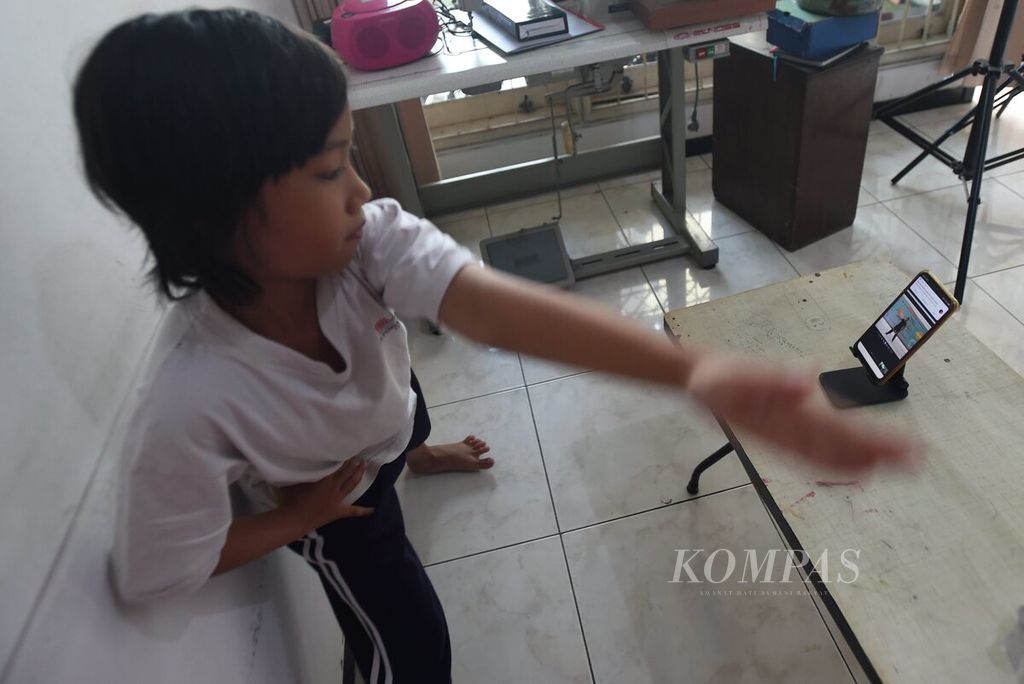 Siswa SD Pembangunan Jaya 2 Sidoarjo, Annada, berolahraga dengan dipandu gurunya secara daring di Sidoarjo, Jawa Timur, Kamis (18/3/2021). Pemerintah menyiapkan pembukaan kembali sekolah tatap muka saat pandemi. Salah satu persiapan adalah memvaksin guru-guru. 