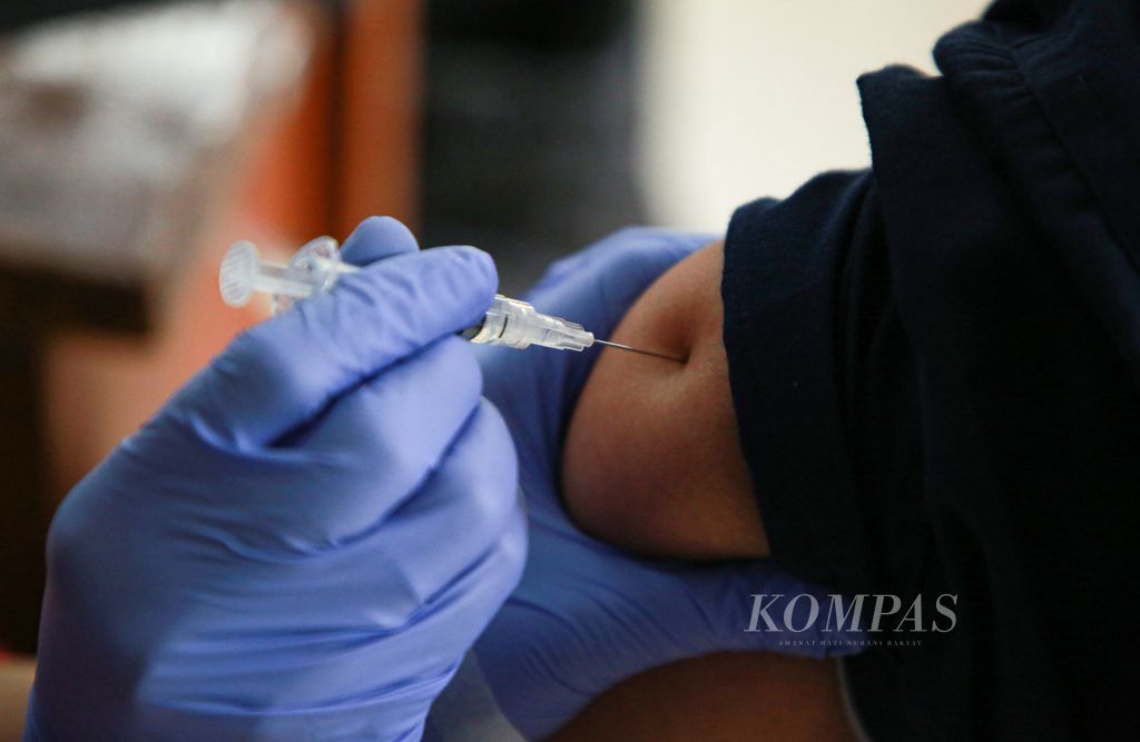  A resident receives the third dose of Covid-19 vaccine or booster at RPTRA Gondangdia, Central Jakarta, Monday (28/3/2022).