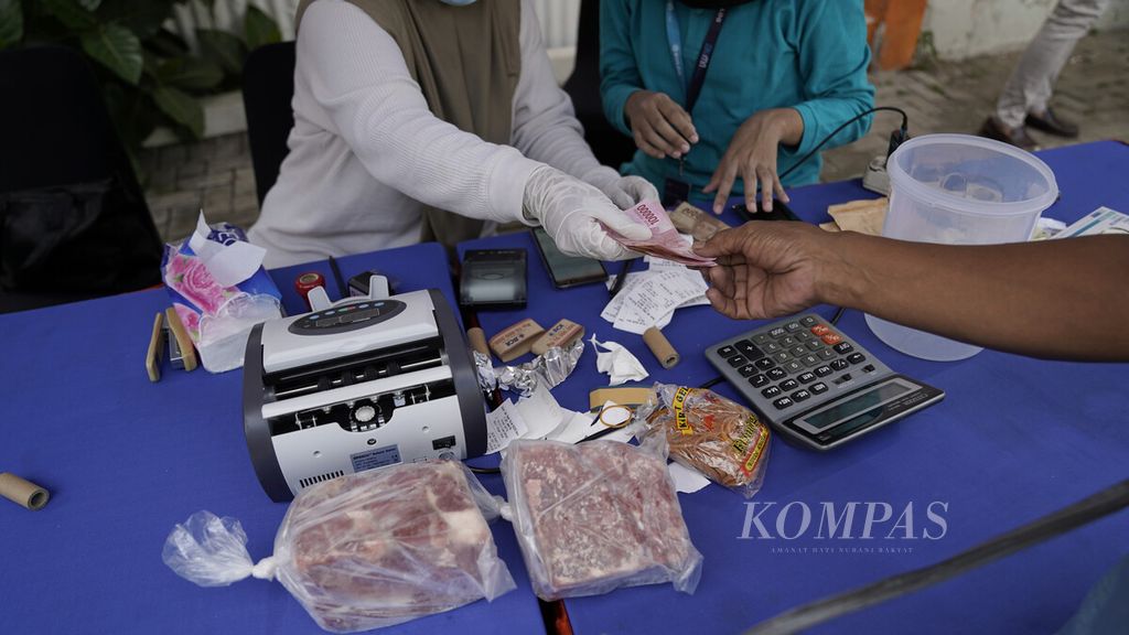 Warga membayar dengan sejumlah uang dalam operasi pasar daging beku oleh Perum Bulog di Rumah Pangan Kita, Jalan Gatot Subroto, Jakarta, Senin (10/5/2021). Daging beku sapi dijual seharga Rp 80.000 per kilogram, sedangkan daging beku kerbau dijual Rp 75.000 per kilogram. Sebanyak 7 ton daging beku kerbau dan 6.800 kilogram daging beku sapi terjual dalam operasi pasar tersebut. Operasi pasar digelar dua hari untuk memastikan ketersediaan pasokan pangan dan menjamin tidak bergejolaknya harga daging menjelang Lebaran. 