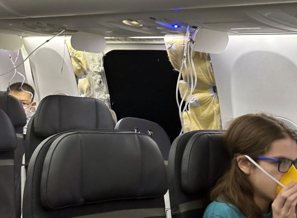 Para penumpang berada di dekat lubang badan pesawat (<i>fuselage</i>) Alaska Airlines Boeing 737 Max 9 dengan nomor penerbangan 1282 yang terpaksa kembali ke Bandara Internasional Portland, AS, pada Jumat (5/1/2024).