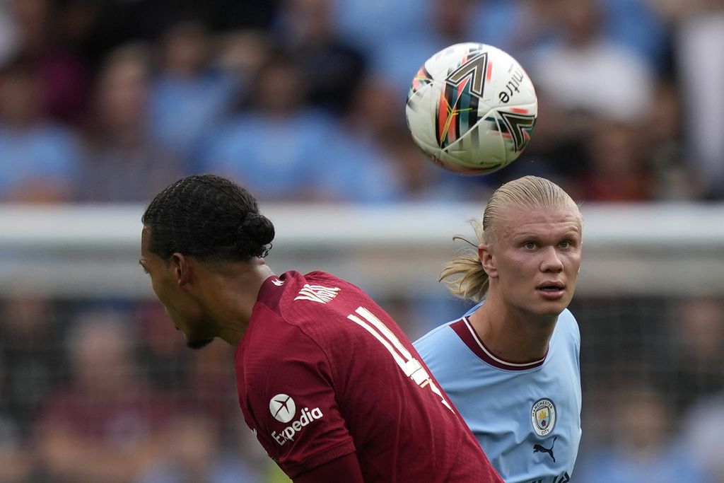 Striker baru Manchester City, Erling Haaland (kanan), menyundul bola melewati bek Liverpool, Virgil van Dijk, pada laga Community Shield 2022 di Stadion King Power, Leicester, Inggris, Sabtu (30/7/2022). Liverpool menang, 3-1, pada laga itu. 