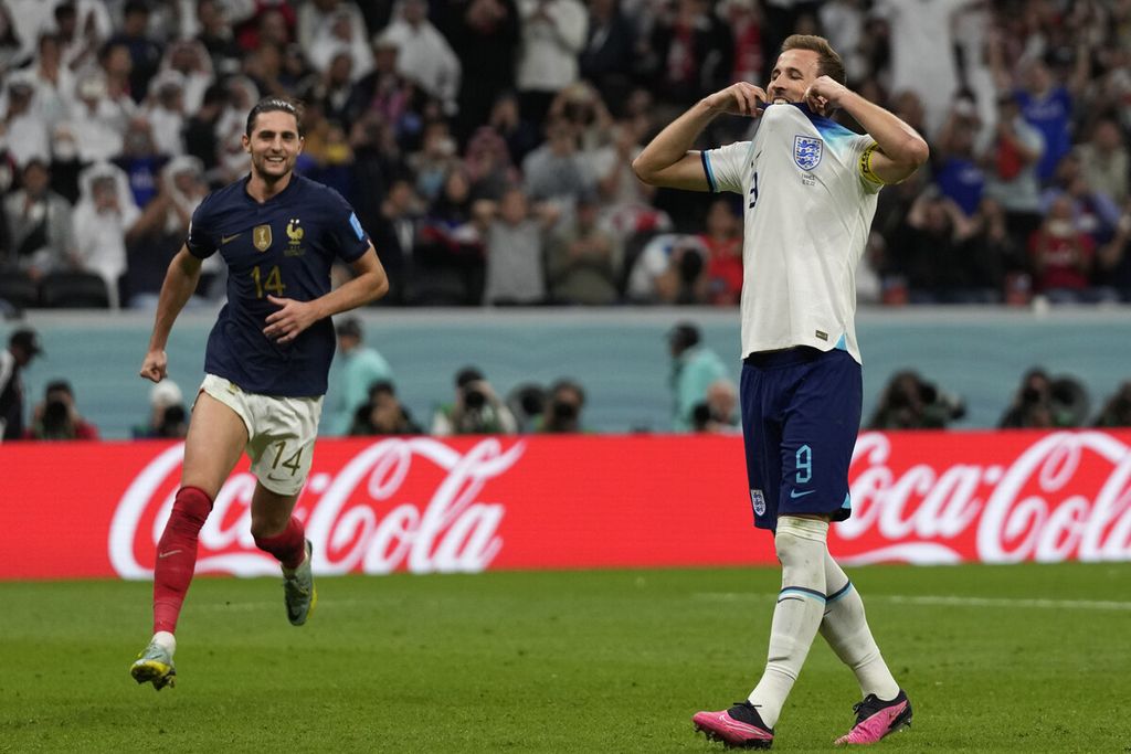 Pemain Inggris Harry Kane bereaksi di samping Adrien Rabiot dari Perancis setelah gagal mengeksekusi tendangan penalti dalam pertandingan sepak bola perempat final Piala Dunia antara Inggris dan Perancis, di Stadion Al Bayt di Al Khor, Qatar, Sabtu (10 /12/2022).