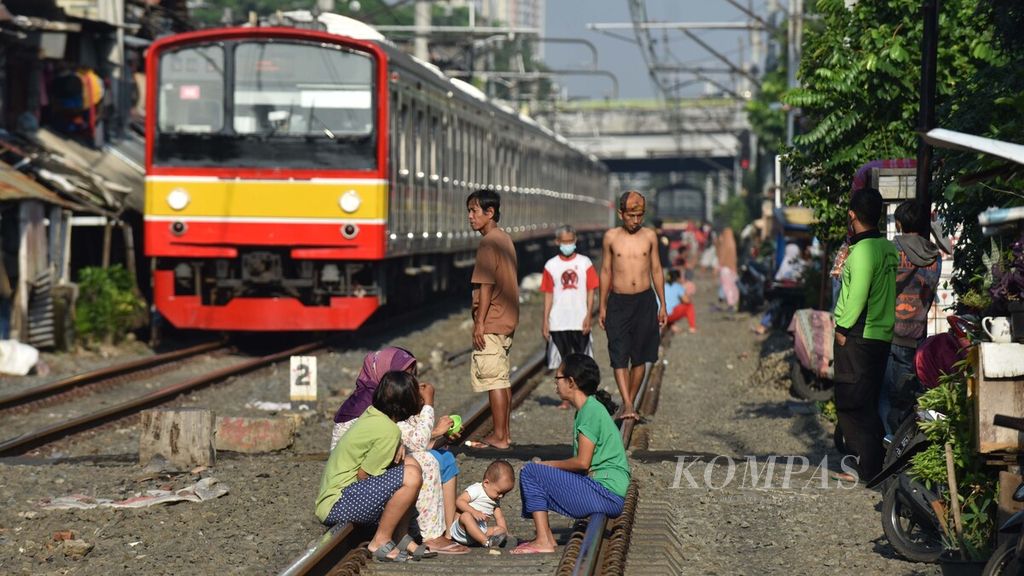 Warga berjemur di atas jalur Kereta Rel Listrik (KRL) Commuter Line di kawasan Pejompongan, Jakarta Pusat, Jumat (2/7/2021). Beberapa waktu belakangan ini, semakin banyak warga yang berjemur ungtuk memperkuat imun tubuh supaya tidak terinfeksi virus Korona. Berjemur sudah banyak dikenal masyarakat untuk menambah vitamin D yang didapat dari sinar matahari. Vitamin D yang terkadung dalam sinar ultraviolet (UV) dari matahari bisa memperkuat sistem kekebalan tubuh yang bisa menangkal berbagai jenis virus penyebab penyakit, termasuk virus Korona yang mengakibatkan Covid-19. Kompas/Wawan H Prabowo
