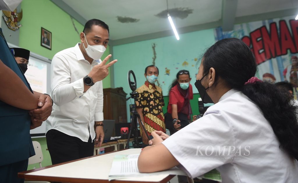 Wali Kota Surabaya Eri Cahyadi berdialog dengan siswa saat mengecek pelaksanaan PTM 100 persen di SD Negeri Kaliasin 01, Surabaya, Jawa Timur, Senin (10/1/2022). Pemerintah Kota Surabaya mulai melaksanakan pembelajaran tatap muka (PTM) 100 persen bagi PAUD, TK, SD, dan SMP pada 10 Januari 2022. PTM 100 persen minggu pertama dibagi dua sif, yakni pagi dan siang. Setiap sif 50 persen. 