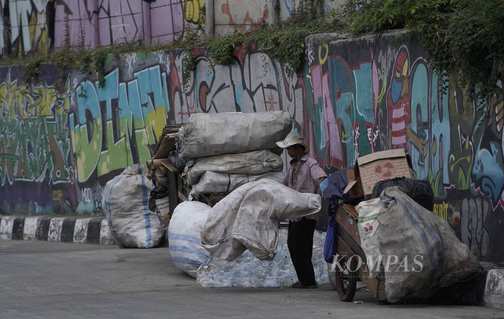Pemulung mengumpulkan rongsokan di samping gerobaknya di kawasan Kampung Melayu, Jakarta Timur, Minggu (9/8/2020). Berdasarkan data Badan Pusat Statistik, terakhir kali ekonomi Indonesia tumbuh negatif pada triwulan I-1999, yakni minus 6,13 persen, sedangkan pada triwulan II-2020, perekonomian Indonesia tumbuh minus 5,32 persen secara tahunan. Pada Maret 2020, ada 26,42 juta orang miskin di Indonesia.