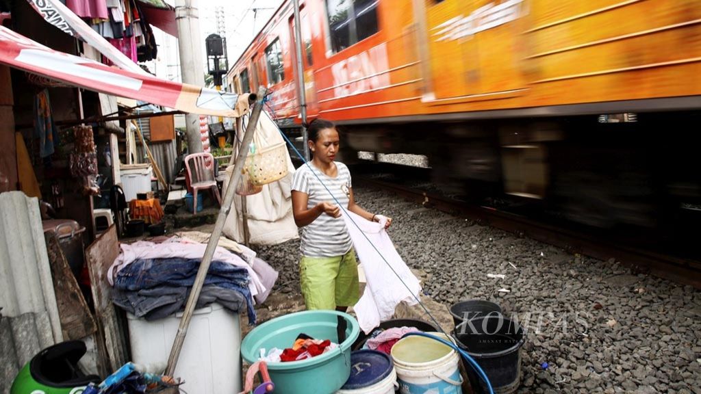 Aktivitas mencuci warga yang tinggal di pinggir rel di kawasan Petamburan, Tanah Abang, Jakarta Pusat, Selasa (15/1/2019). Badan Pusat Statistik merilis data jumlah penduduk miskin pada September 2018 sebesar 25,67 juta orang, menurun 0,28 juta orang terhadap Maret 2018 dan menurun 0,91 juta orang terhadap September 2017.