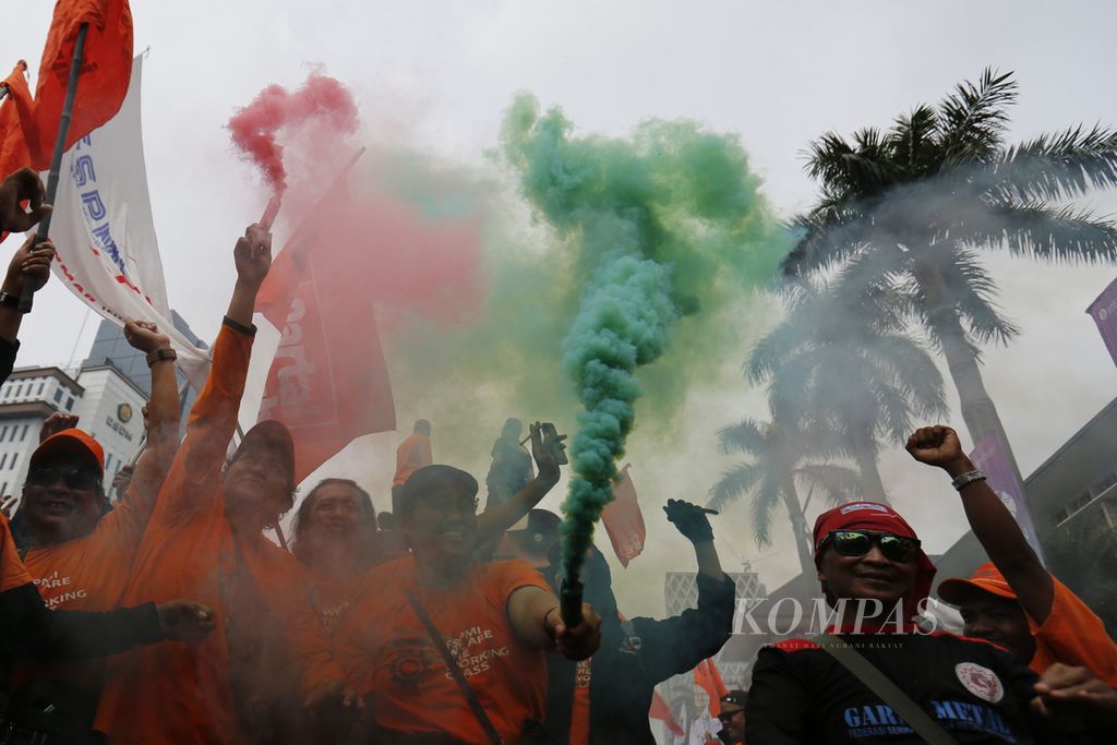 Buruh menggelar aksi damai saat merayakan Hari Buruh Internasional atau May Day di kawasan Patung Kuda, Jalan MH Thamrin, Jakarta, Senin (1/5/2023). Mereka, antara lain, menuntut pencabutan UU Cipta Kerja.