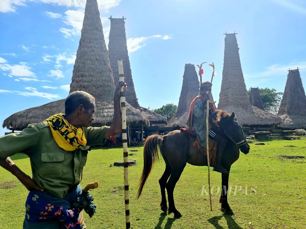 Beberapa laki-laki di Kampung Adat Ratenggaro, Desa Maliti Bondo Ate, Kodi Bangedo, Sumba Barat Daya, NTT, Minggu (12/3/2023), melakukan persiapan untuk upacara adat Pasalo, yang akan berlangsung Senin (13/3/2023). Sebelum acara adat mereka ikut kegiatan vaksinasi di lokasi kampung adat tersebut. 