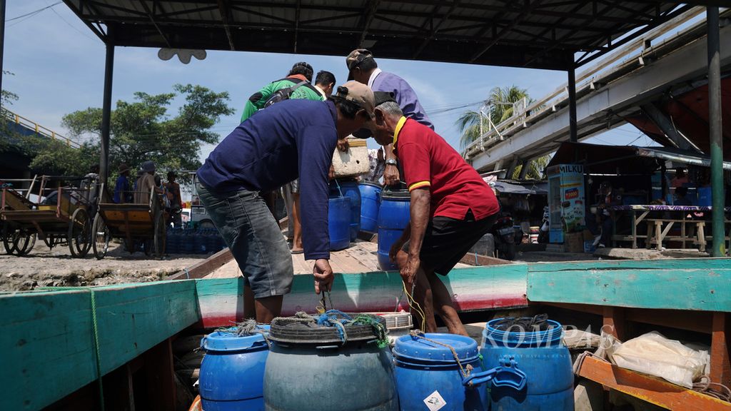 Pekerja menurunkan hasil laut dan tambak dari kapal motor Sinar Ada jurusan Muaragembong-Cilincing merapat di muara Kali Rawa Malang, Cilincing, Jakarta Utara, Jumat (28/10/2022). Penumpang membayar ongkos tiket Rp 25 ribu. Ongkos pelayaran naik Rp 5.000 setelah harga BBM naik. Selain jasa angkut penumpang, perahu juga melayani pengangkutan barang kebutuhan sehari-hari dan hasil laut. Jadwal perahu motor untuk perjalanan Cilincing-Muaragembong adalah dua kali dalam sehari, yakni pukul 11.00 WIB dan pukul 12.00 WIB. Kapal motor Muaragembong-Cilincing pulang pergi menghabiskan 20 liter pertalite, kalau ada angin barat bisa menghabiskan 25 liter pertalite. 