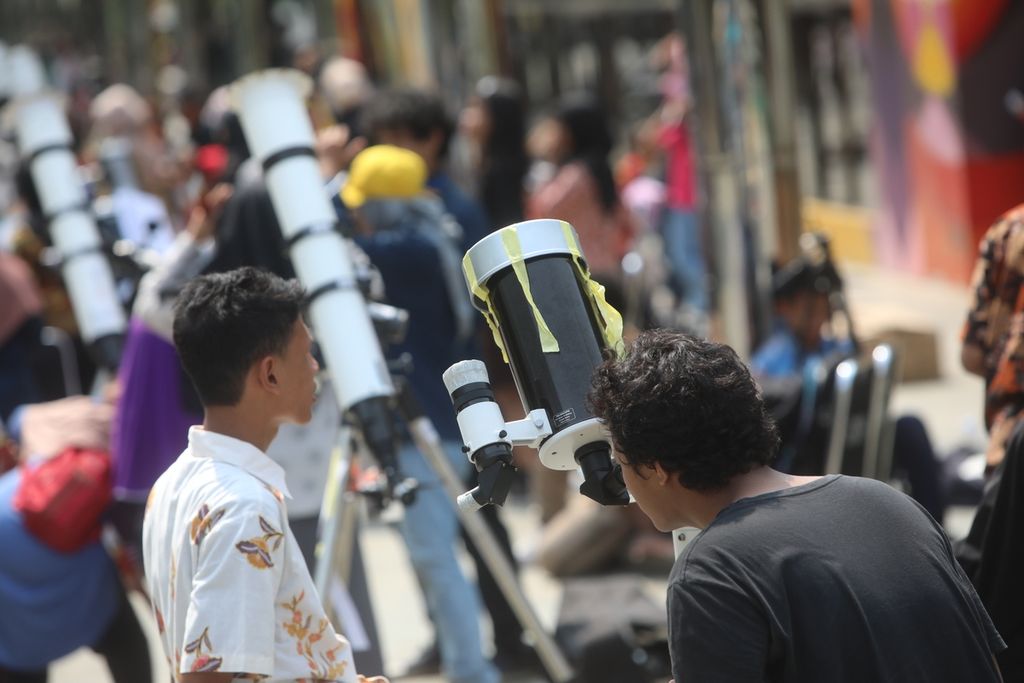 Warga mengamati fenomena gerhana matahari cincin dengan teleskop di kompleks Taman Ismail Marzuki (TIM), Jakarta Pusat, Kamis (26/12/2019). Sejumlah komunitas pemerhati astronomi menyediakan teleskop untuk pengamatan umum oleh masyarakat.