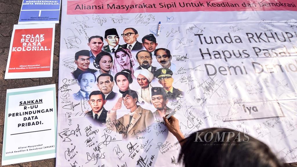 Warga menandatangani spanduk Aliansi Masyarakat untuk Keadilan Demokrasi yang menolak RKUHP di Bundaran Hotel Indonesia, Jakarta, Minggu (15/9/2019). Sejumlah pihak menilai RKUHP berisi banyak pasal karet dan bermasalah yang bisa meningkatkan potensi masyarakat tersandung kasus pidana.