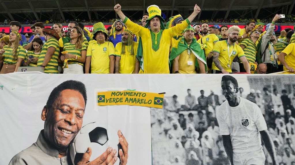 Suporter timnas Brasil membentangkan spanduk bergambar legenda sepak bola Pele sebelum pertandingan babak 16 besar Piala Dunia Qatar 2022 antara Brasil dan Korea Selatan di Stadion Educatiion City, Al Rayyan, Qatar, Senin (5/12/2022).  Argentina, Uruguay, Chile, dan Paraguay resmi mengajukan diri sebagai calon tuan rumah Piala Dunia 2030 pada Rabu (8/2/2023).