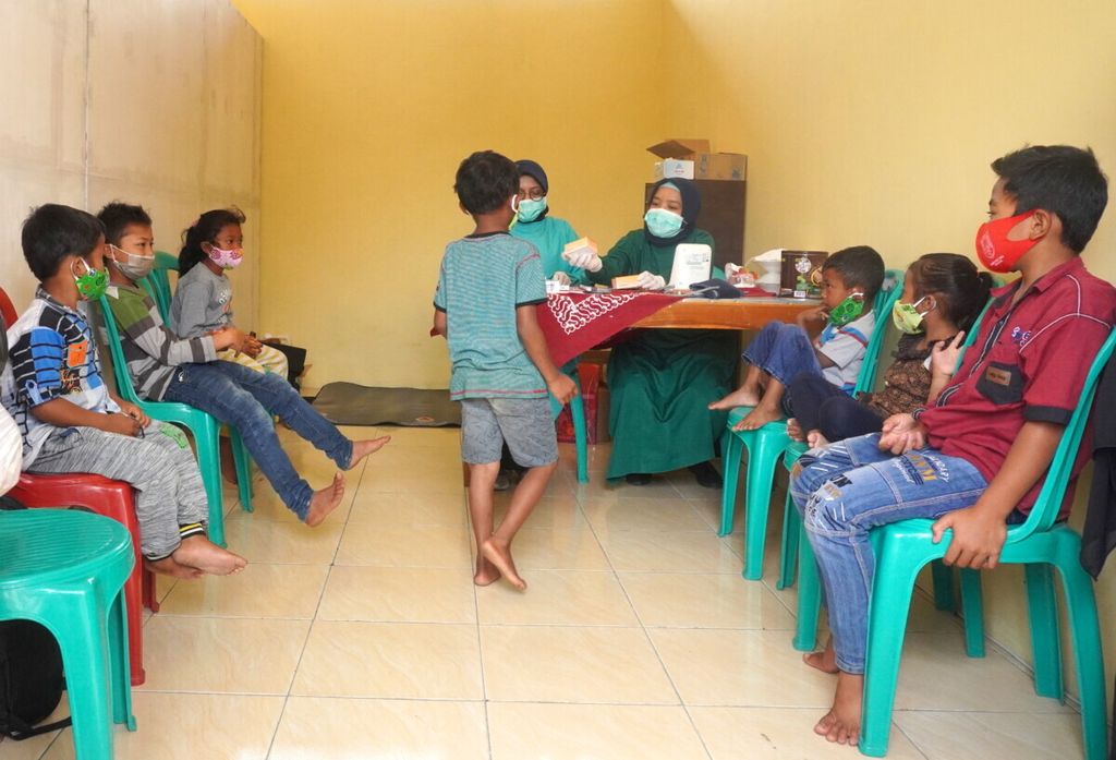 Anak-anak pengungsi mendapatkan obat flu seusai memeriksakan diri di pengungsian Balai Desa Deyangan, Kecamatan Mertoyudan, Kabupaten Magelang, Jawa Tengah, November 2020.