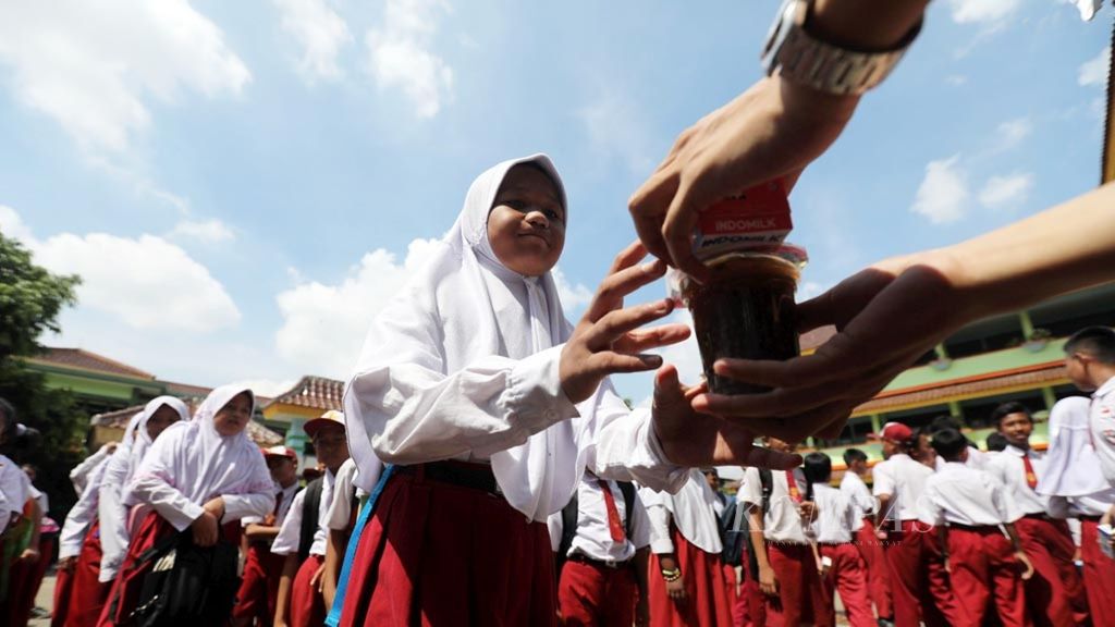 Murid SDN 03/05 Muara Angke, Penjaringan, Jakarta Utara, menerima pembagian makanan tambahan untuk anak sekolah berupa susu UHT dan bubur kacang hijau dari Pemprov DKI Jakarta, Senin (2/4/2018). 