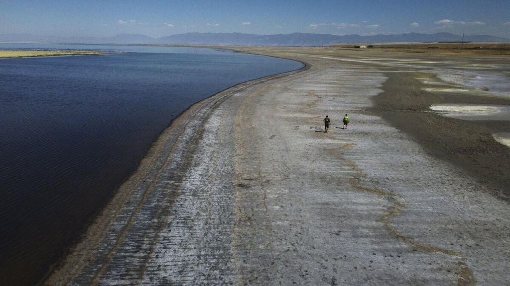 Warga berjalan kaki di area yang surut setelah rekor level air terendah terlihat di Great Salt Lake, Utah, Amerika Serikat, Selasa (6/9/2022). Gelombang panas berkepanjangan telah memecahkan rekor di Utah ketika suhu udara mencapai 105 derajat fahrenheit (40,5 derajat celsius) pada Selasa itu. Kondisi itu menjadikannya hari terpanas pada bulan September yang tercatat sejak tahun 1874.