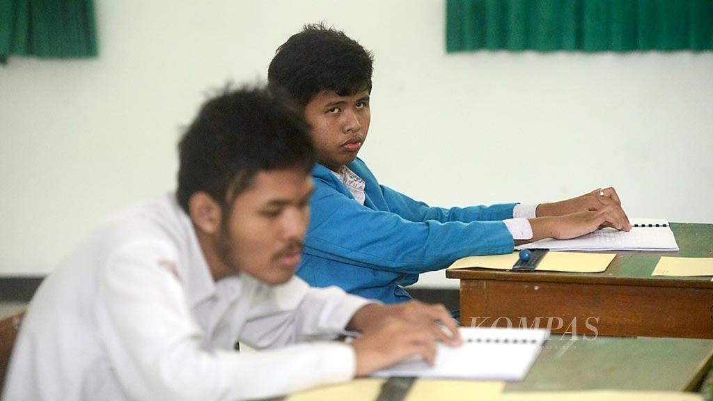 Murid penderita<i> low vision</i> mengikuti ujian nasional mata pelajaran Matematika dengan soal yang dibacakan oleh pengajar mereka di sekolah inklusi Madrasah Aliyah Negeri Maguwoharjo, Kecamatan Depok, Sleman, Daerah Istimewa Yogyakarta, Selasa (5/4/2016). Keberadaan sekolah inklusi memungkinkan pelajar difabel mendapatkan kesempatan setara dengan murid lainnya dalam mengikuti ujian nasional dan meraih kelulusan.